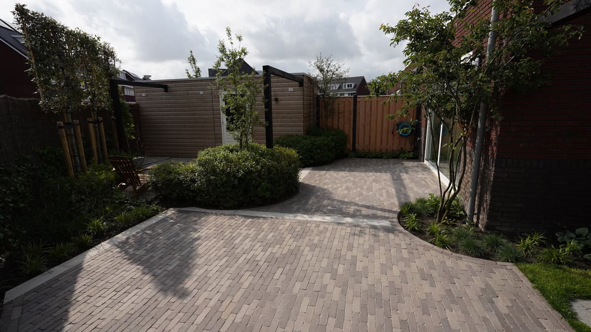Achtertuin met terras en weelderige groene beplanting